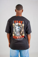 Person wearing a black t-shirt with a graphic design and text on the back, standing against a plain background.